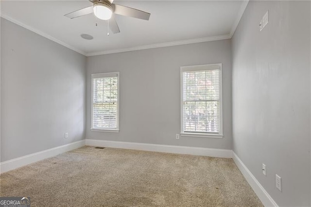 unfurnished room with ceiling fan, light colored carpet, and ornamental molding