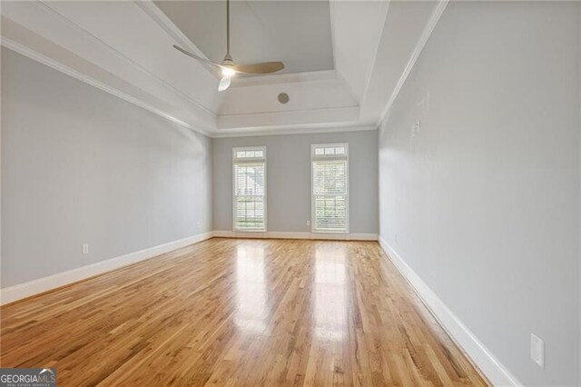 spare room featuring crown molding, ceiling fan, a tray ceiling, and light hardwood / wood-style floors