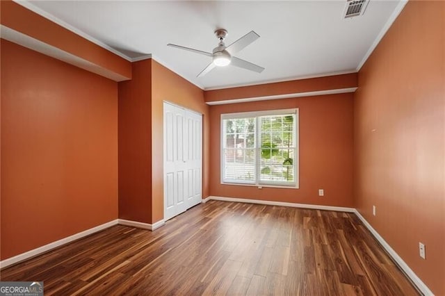 unfurnished room with dark hardwood / wood-style flooring, ornamental molding, and ceiling fan