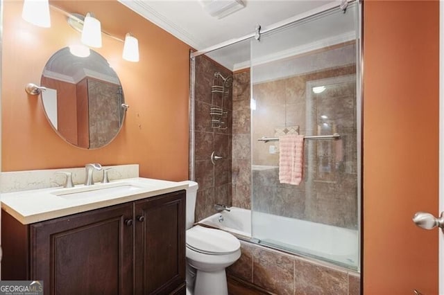 full bathroom featuring ornamental molding, vanity, shower / bath combination with glass door, and toilet