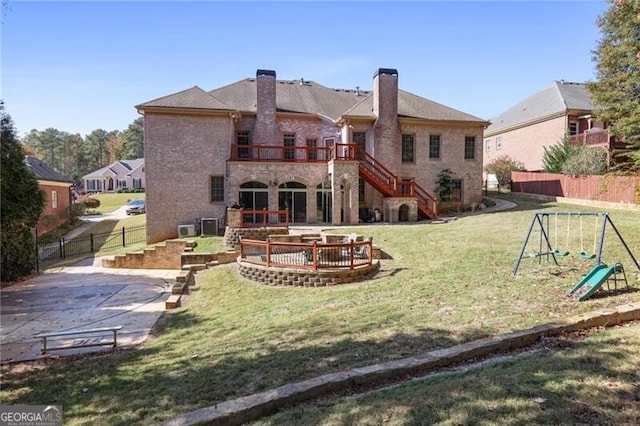 back of property with a balcony, a yard, a playground, and a patio area