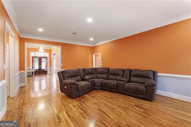 living room featuring crown molding, light hardwood / wood-style flooring, and french doors