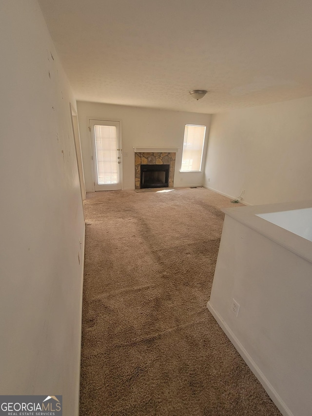 unfurnished living room with a fireplace and carpet