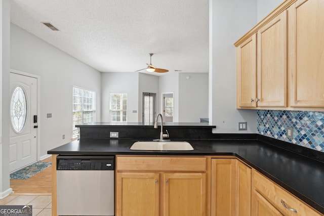 kitchen with sink, stainless steel dishwasher, light brown cabinetry, and light tile patterned floors