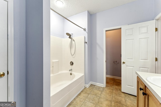 bathroom with vanity, washtub / shower combination, and a textured ceiling