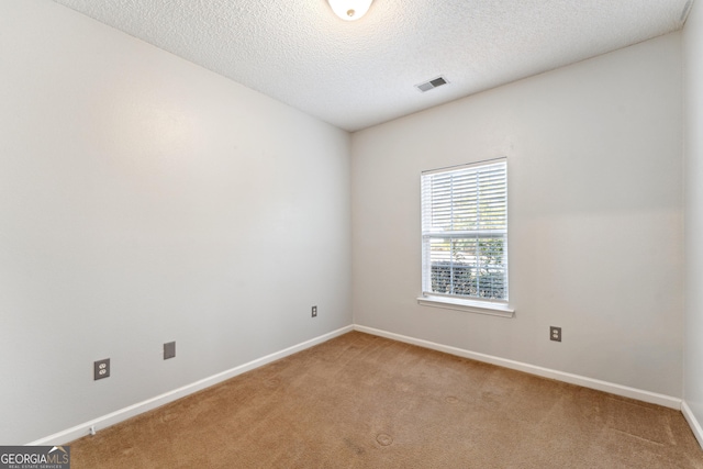 unfurnished room featuring carpet flooring and a textured ceiling