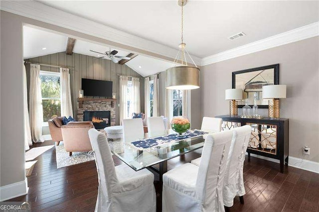 dining space featuring dark hardwood / wood-style flooring, vaulted ceiling with beams, a fireplace, and ceiling fan