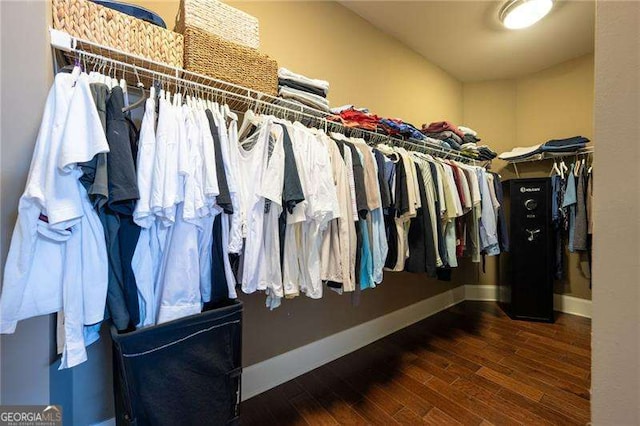 spacious closet with dark hardwood / wood-style flooring