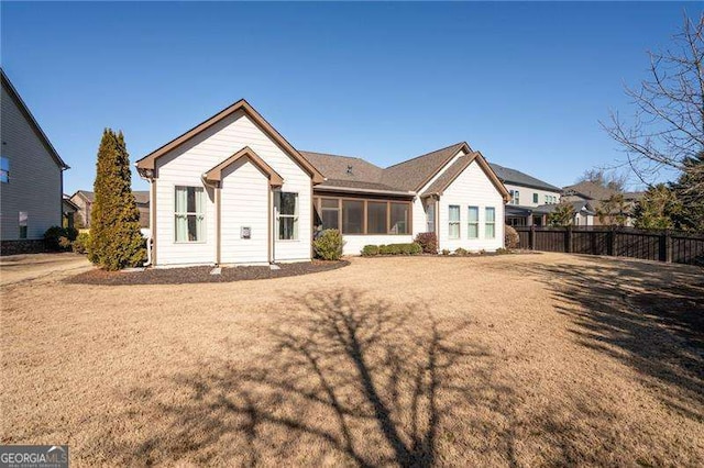 rear view of property featuring a lawn