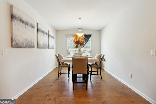 dining room with an inviting chandelier and dark hardwood / wood-style flooring