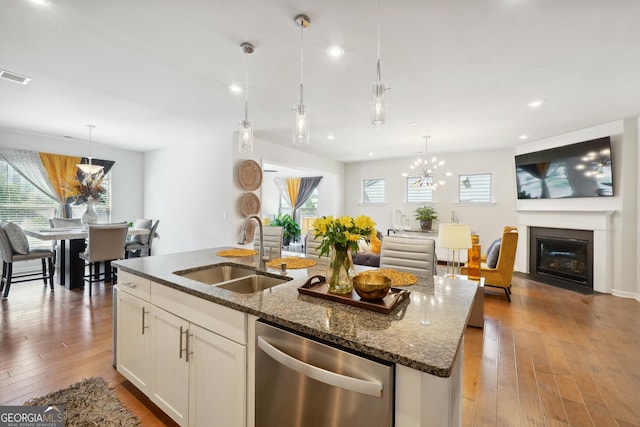 kitchen with pendant lighting, sink, stainless steel dishwasher, and white cabinets