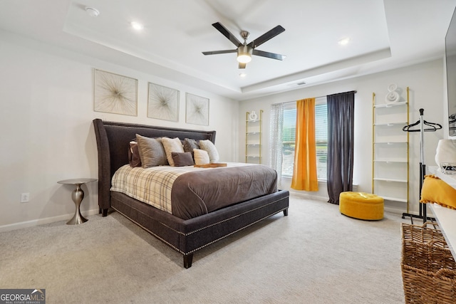 bedroom with ceiling fan, a raised ceiling, and carpet floors