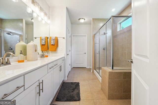 bathroom with tile patterned flooring, vanity, and walk in shower