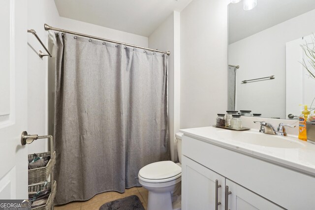 bathroom featuring tile patterned flooring, vanity, curtained shower, and toilet