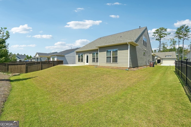 rear view of house featuring a yard and a patio