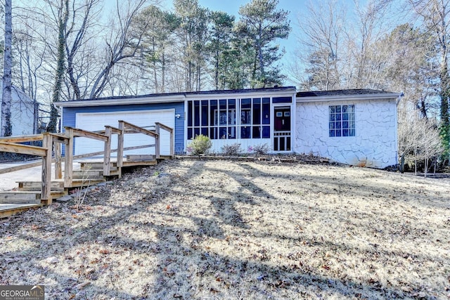 view of front of property with a garage and a sunroom