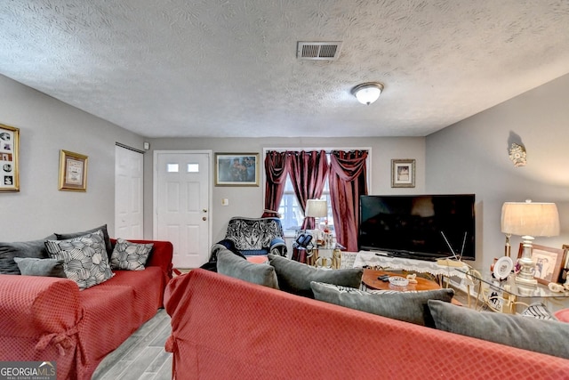 living room with wood-type flooring and a textured ceiling