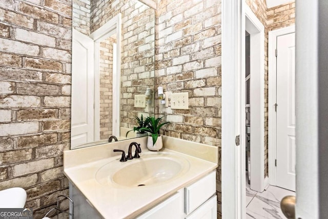 bathroom with brick wall and vanity