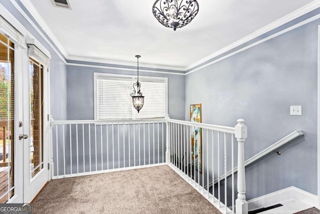 corridor with a wealth of natural light, ornamental molding, and carpet