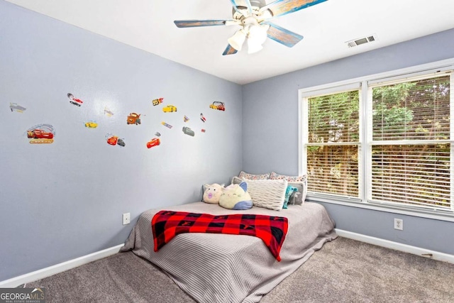 bedroom with multiple windows, ceiling fan, and carpet