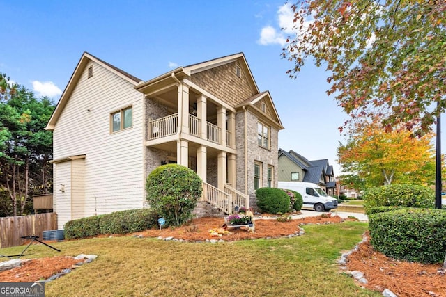 view of home's exterior with a balcony, a yard, and central AC