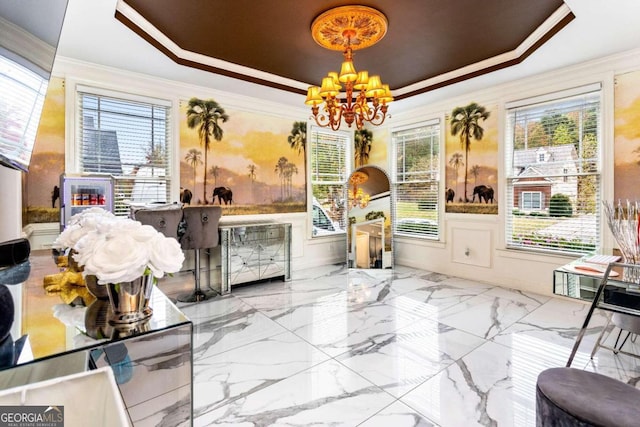 interior space with ornamental molding, an inviting chandelier, and a tray ceiling