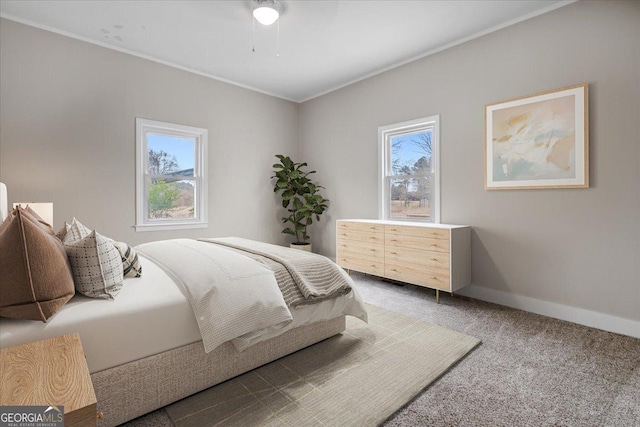 bedroom featuring multiple windows, crown molding, and carpet floors