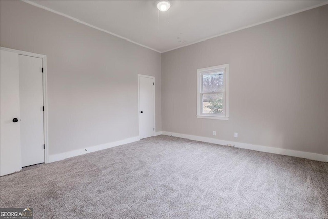 unfurnished room featuring ornamental molding and carpet flooring