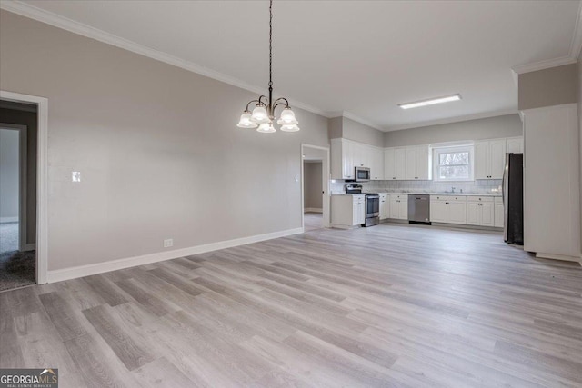 kitchen with crown molding, pendant lighting, stainless steel appliances, decorative backsplash, and white cabinets