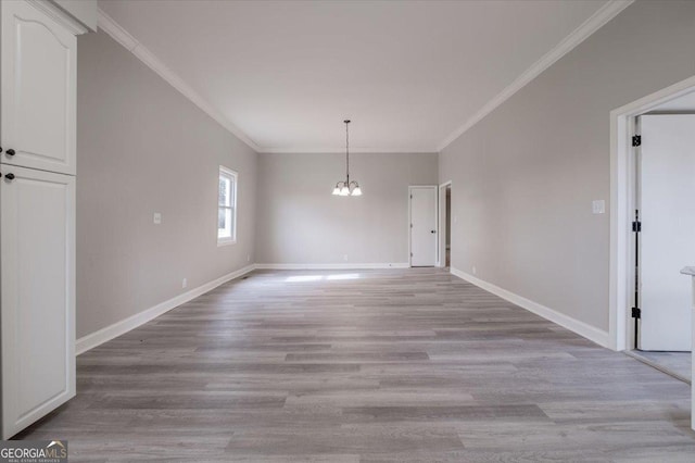 unfurnished dining area featuring crown molding, a chandelier, and light wood-type flooring