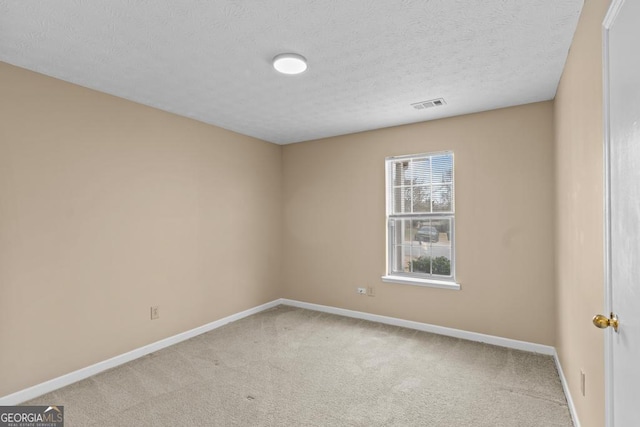 empty room featuring light carpet and a textured ceiling