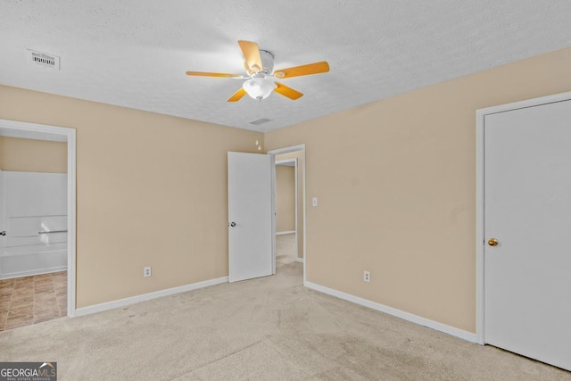 unfurnished bedroom with ceiling fan, light carpet, and a textured ceiling