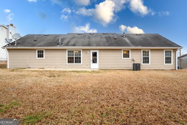 rear view of property featuring cooling unit and a lawn