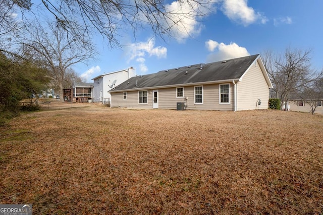 back of house featuring central AC and a lawn