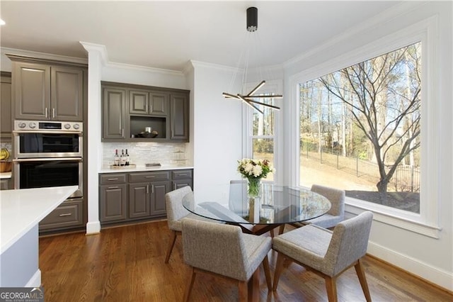 dining area featuring ornamental molding and dark hardwood / wood-style floors