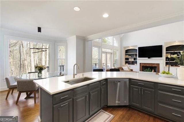 kitchen with pendant lighting, sink, crown molding, dark wood-type flooring, and dishwasher