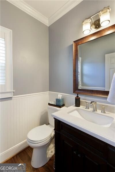 bathroom with vanity, hardwood / wood-style floors, crown molding, and toilet