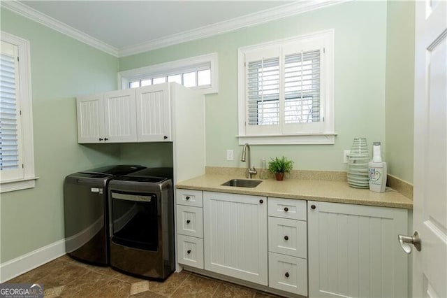 laundry area with sink, dark tile patterned floors, cabinets, independent washer and dryer, and ornamental molding