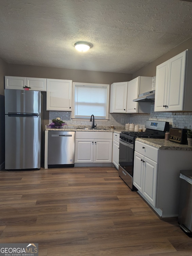 kitchen with sink, white cabinetry, tasteful backsplash, dark hardwood / wood-style floors, and stainless steel appliances