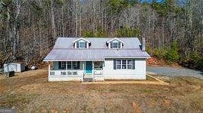 cape cod home with a front yard