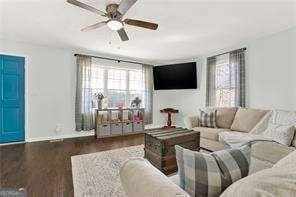 living room with ceiling fan and dark hardwood / wood-style flooring