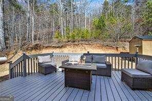 wooden terrace featuring an outdoor living space with a fire pit