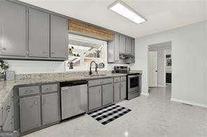 kitchen with gray cabinets, appliances with stainless steel finishes, and sink