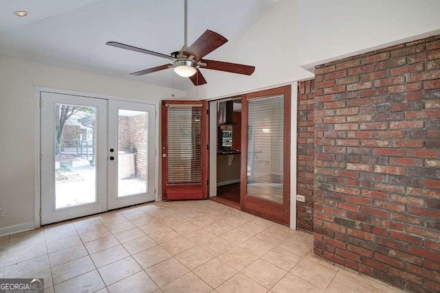 interior space featuring brick wall, ceiling fan, and french doors