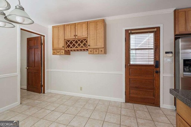 kitchen featuring crown molding, light tile patterned flooring, and stainless steel fridge with ice dispenser