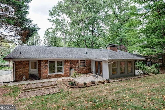 rear view of house with a yard, a patio area, and french doors