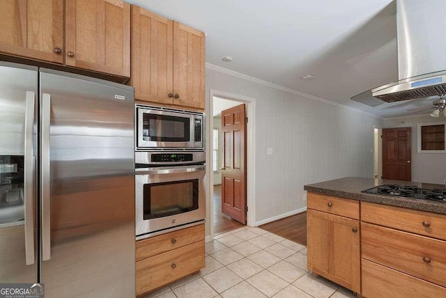 kitchen with island exhaust hood, light tile patterned floors, appliances with stainless steel finishes, ornamental molding, and ceiling fan