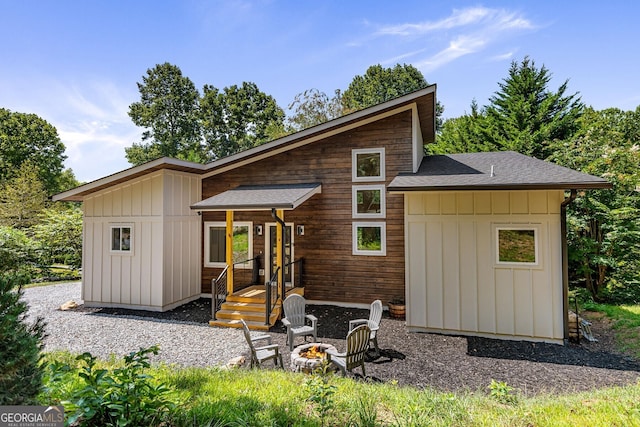 back of house featuring an outdoor fire pit