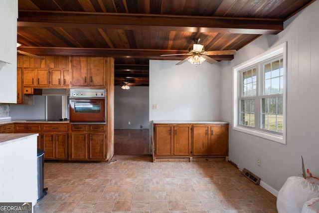 kitchen with wooden ceiling, black electric cooktop, beamed ceiling, ceiling fan, and oven