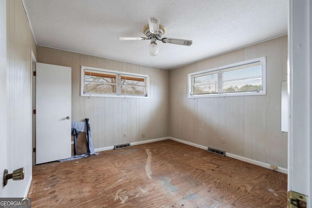 empty room with a textured ceiling and ceiling fan